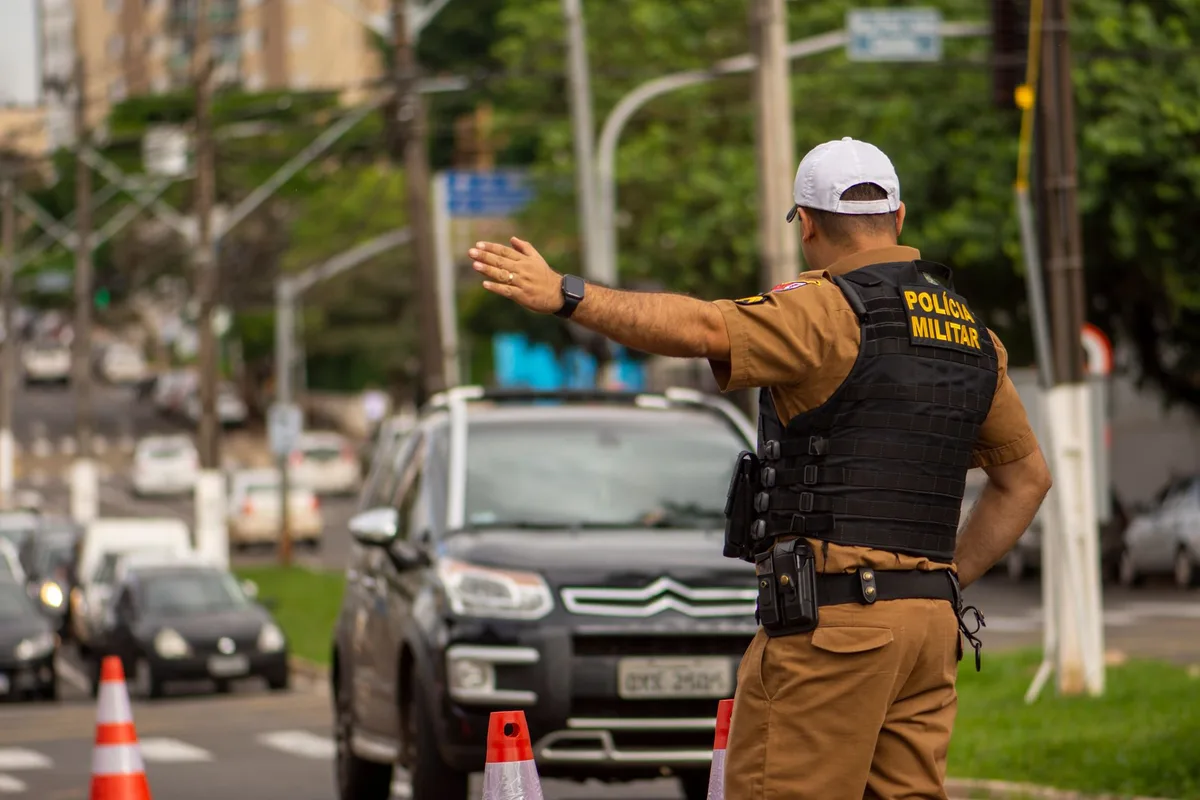 Agente de policía de tráfico dirigiendo el tráfico en una intersección urbana concurrida