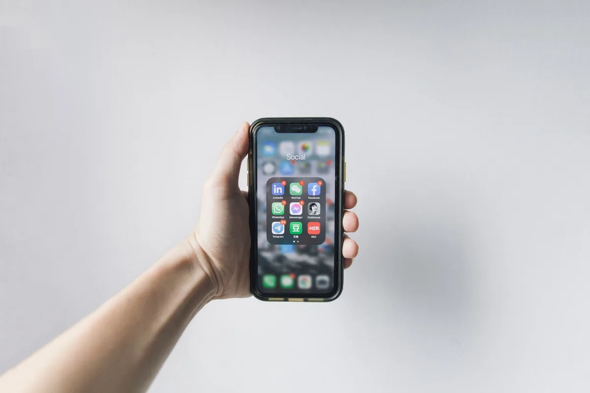 Smartphone screen showing Instagram Reel with download button highlighted, user's thumb near the interface element, clean mobile home setting