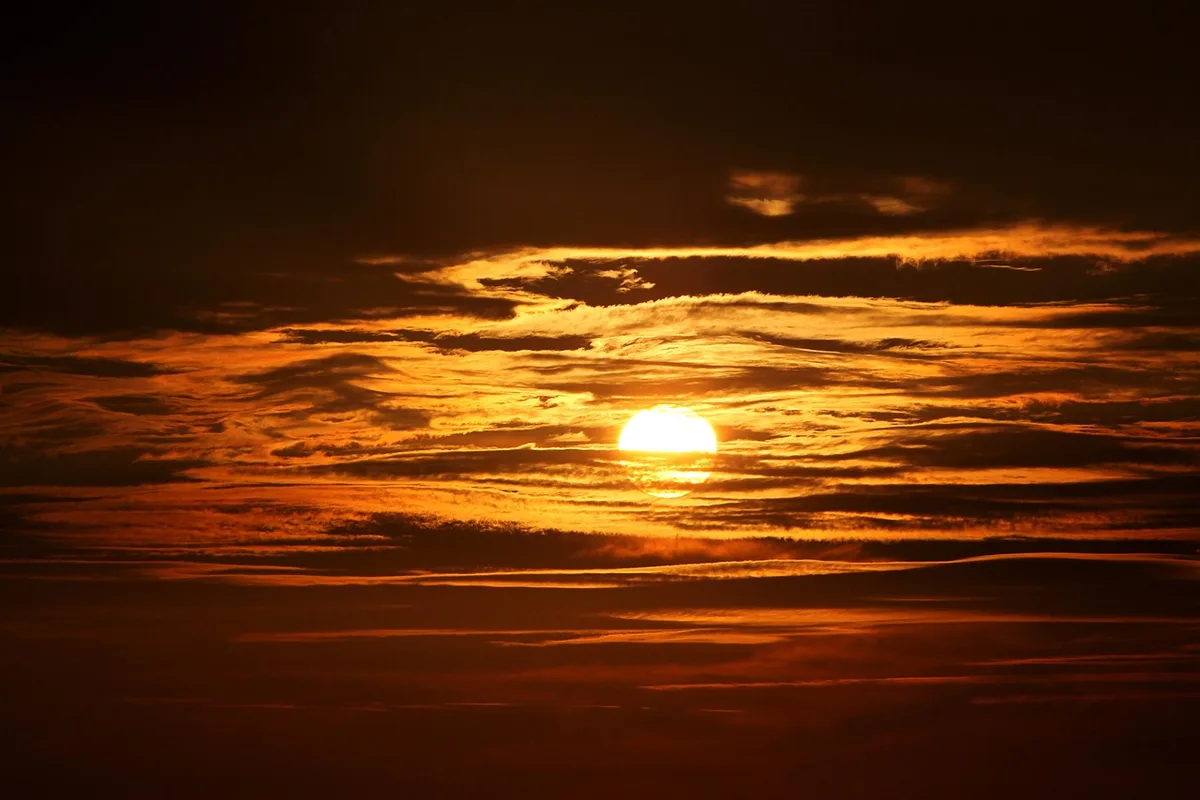 Sol bajo en el horizonte occidental durante el atardecer, con cielo despejado hacia poniente