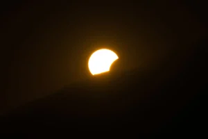 Gafas de eclipse sobre una superficie neutra con luz brillante de fondo