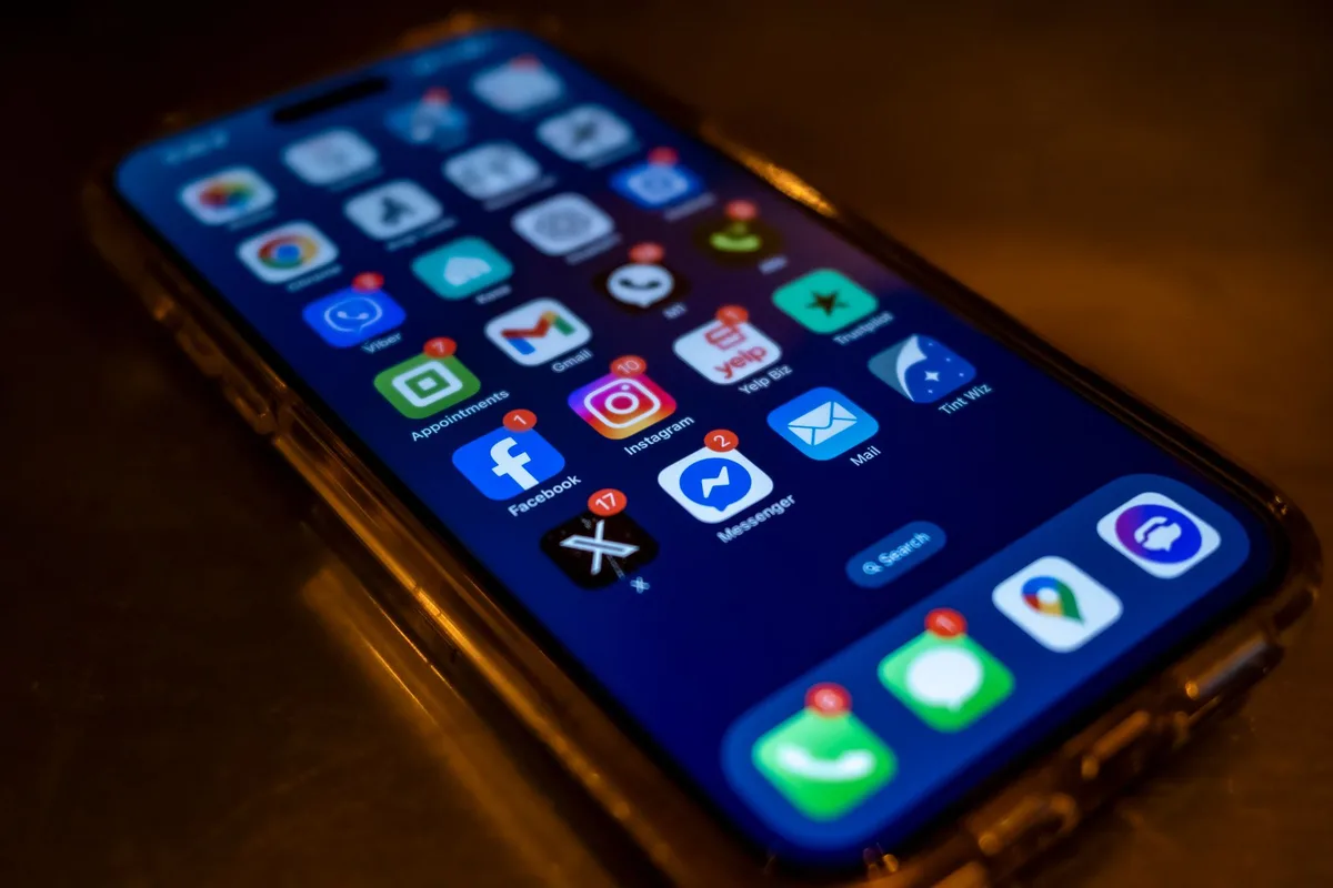 A sleek smartphone display showing software update progress, with a subtle glow and clean interface elements, symbolizing the refinement process of a major operating system release