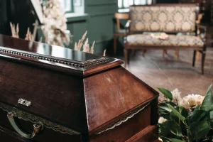 Puerta cerrada de una funeraria con flores y coronas, pasillo oscuro visible — cierre definitivo