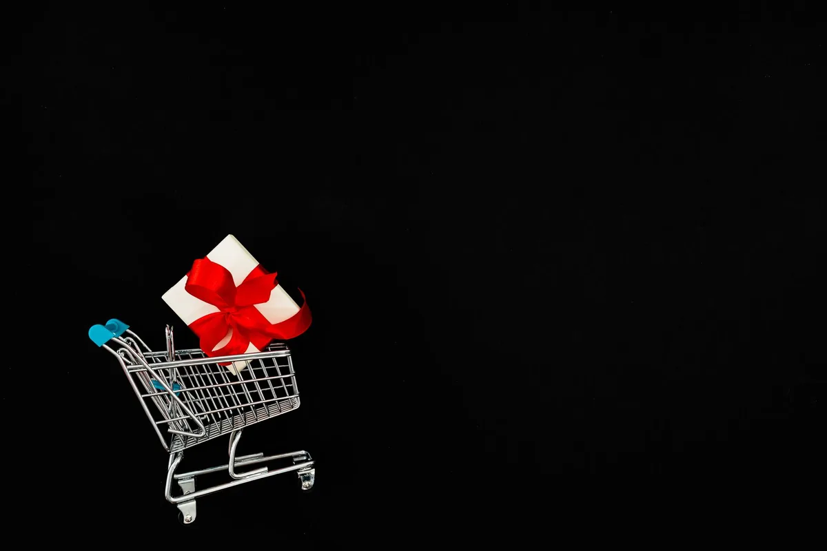 Shopping cart filled with tech devices on a laptop screen, glowing with promotional discount badges, blue and red color scheme emphasizing urgency