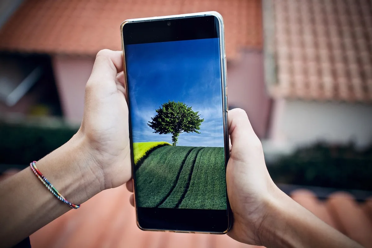 A high-end smartphone's triple camera module in close-up, each lens catching light differently, showcasing the optical zoom design and metal construction, mounted on a sleek device body