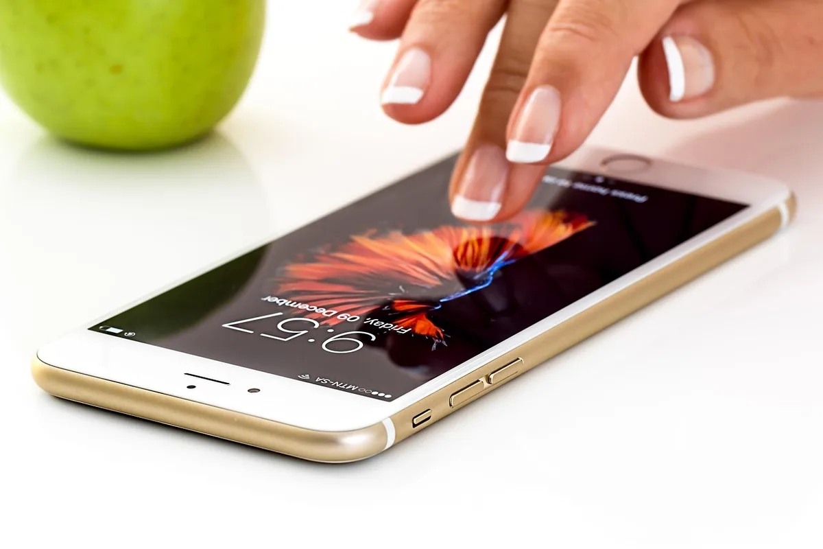 A sleek smartphone displaying a vibrant OLED screen with Android interface, sitting on a minimalist desk with soft natural lighting emphasizing the display's brightness and color depth