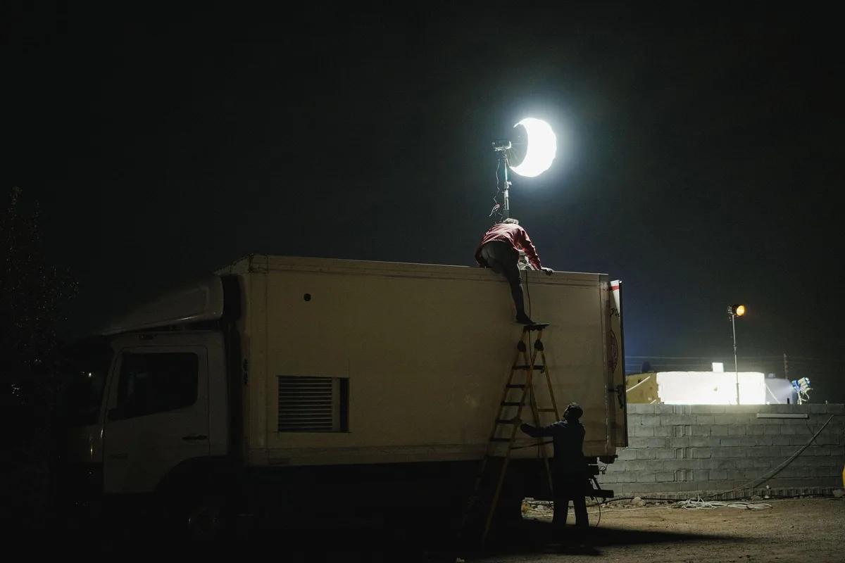 Equipo de producción televisiva trabajando en un rodaje nocturno intenso