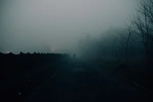 Pueblo aislado envuelto en niebla con atmósfera misteriosa y claustrofóbica
