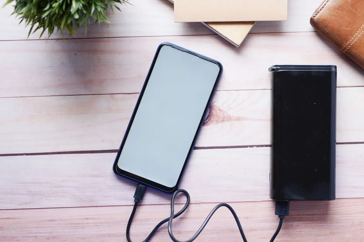 Smartphone battery indicator showing full charge with animated lightning bolt and energy visualization, representing extended battery life and durability over time.