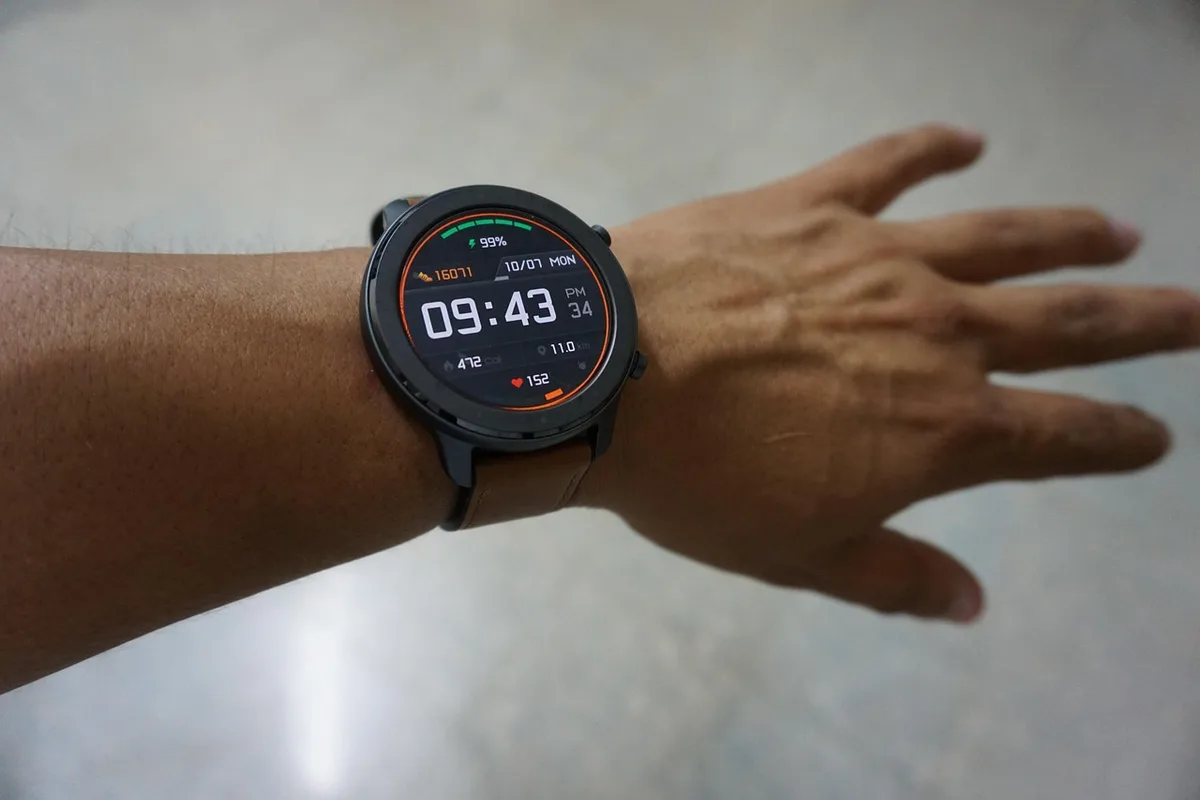 Close-up on an anonymous hands-on demo area with a generic smartwatch on a stand and a small tag showing a discounted price