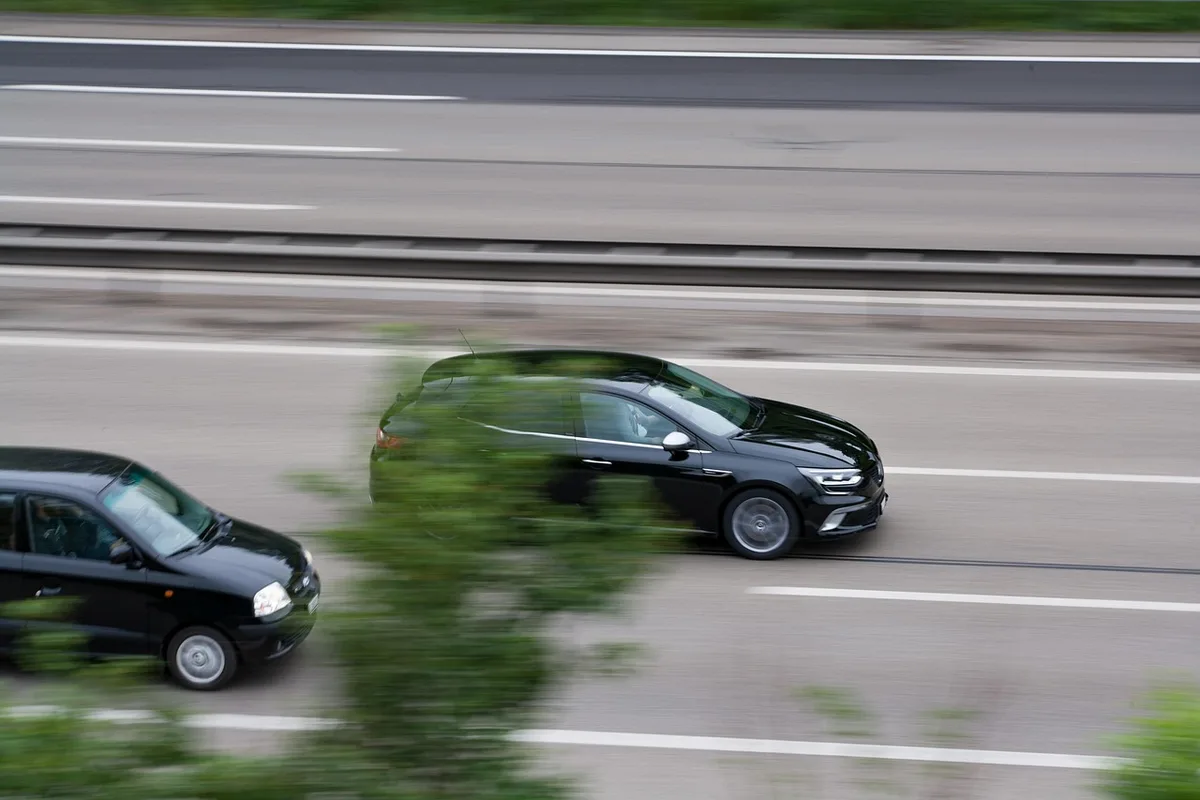 Agente de tráfico usando un dispositivo portátil de medición de velocidad en una carretera