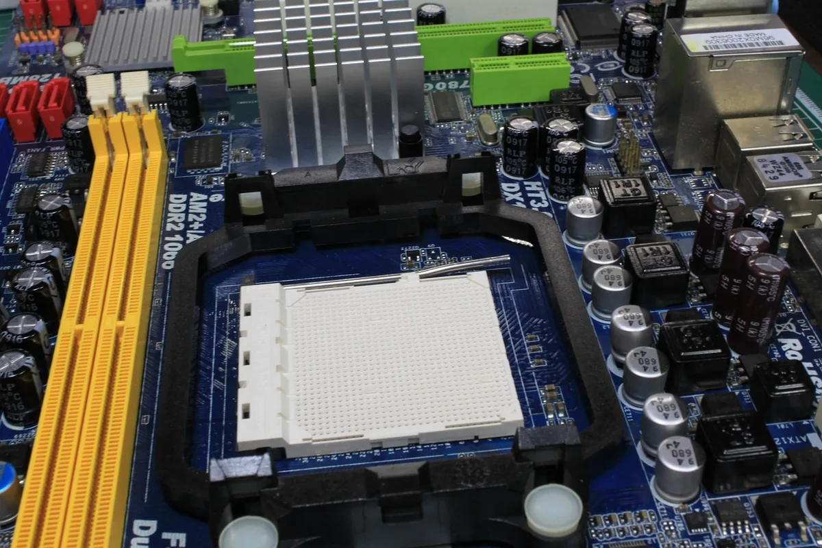 A close-up of an anonymous PC motherboard area showing an unbranded soldered SoC and passive cooling, with a small sticker reading "unbranded" blurred out