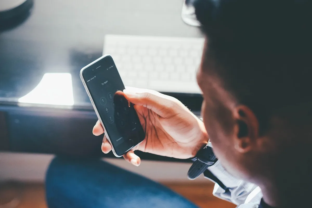 Empty iPhone on a desk showing generic AI wave graphic on screen, soft natural light
