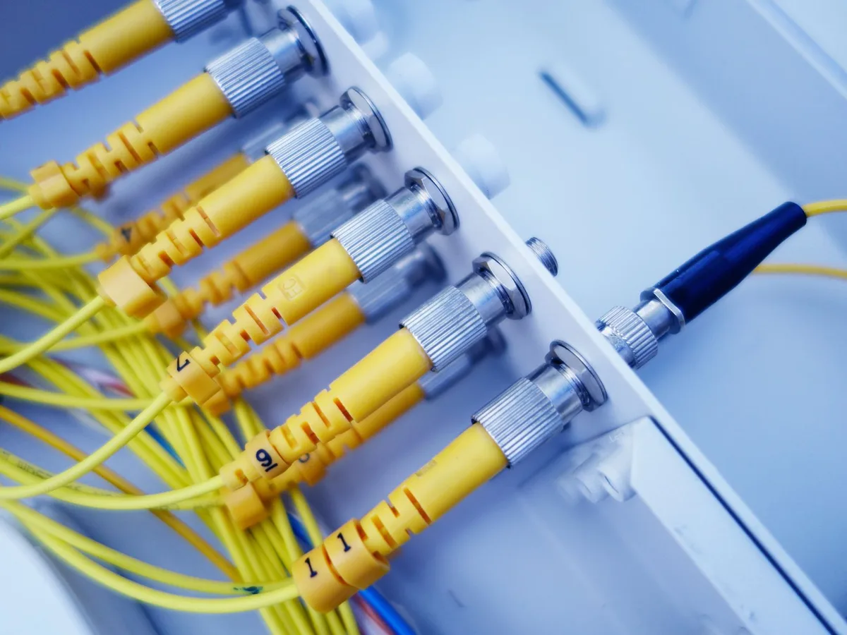 Empty communications rack and generic base station equipment in a technical room, cables coiled neatly, no logos or identifiable hardware