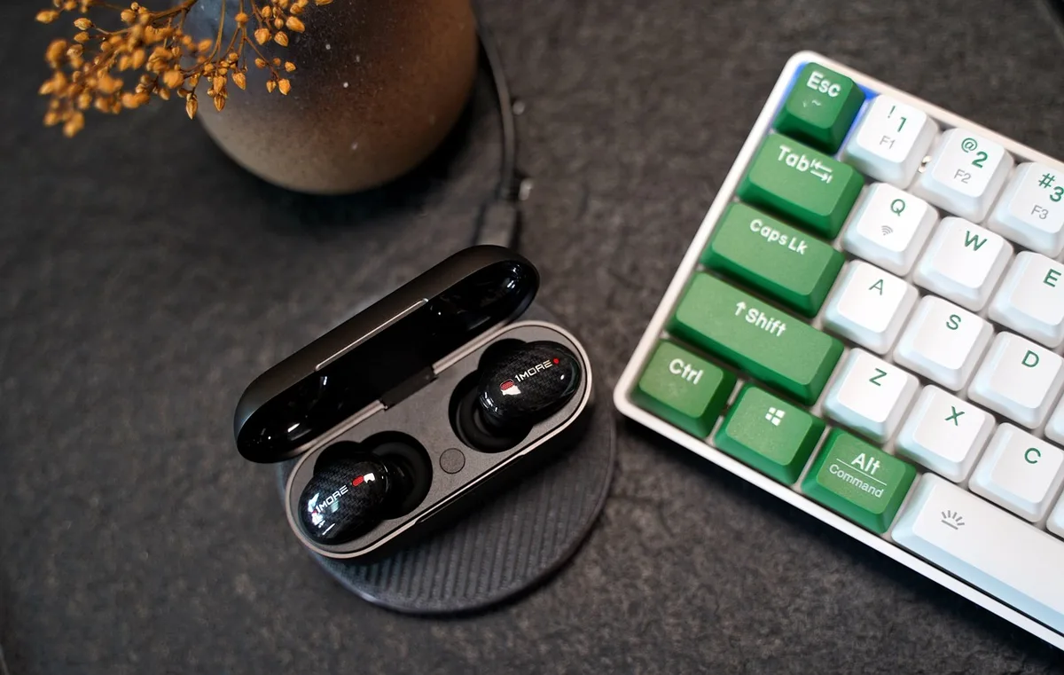A gaming PC setup with a wireless controller held above a keyboard, with a subtle Bluetooth icon or connection indicator visible in the background, representing wireless connectivity.