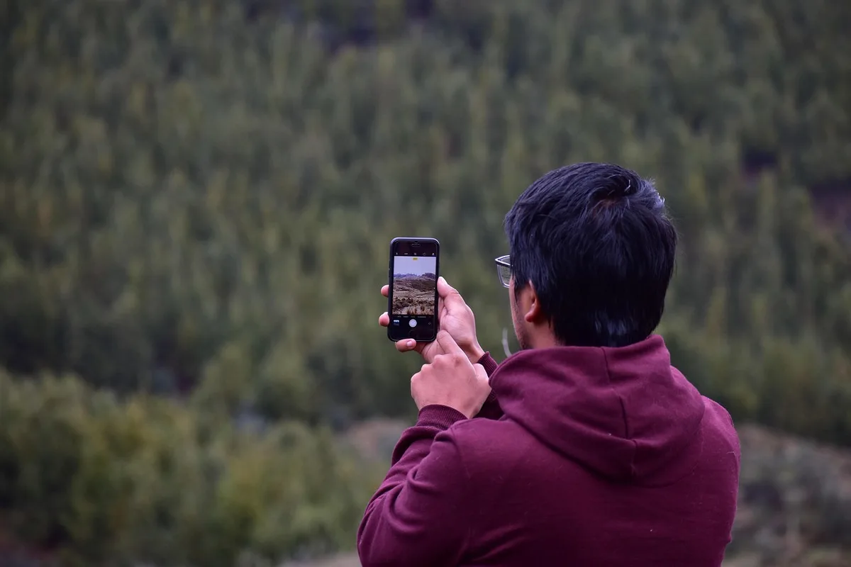 A close-up of the smartphone's camera module and rear design, with warm light reflecting off the metallic frame and glass back, emphasizing the premium build quality and multi-lens setup