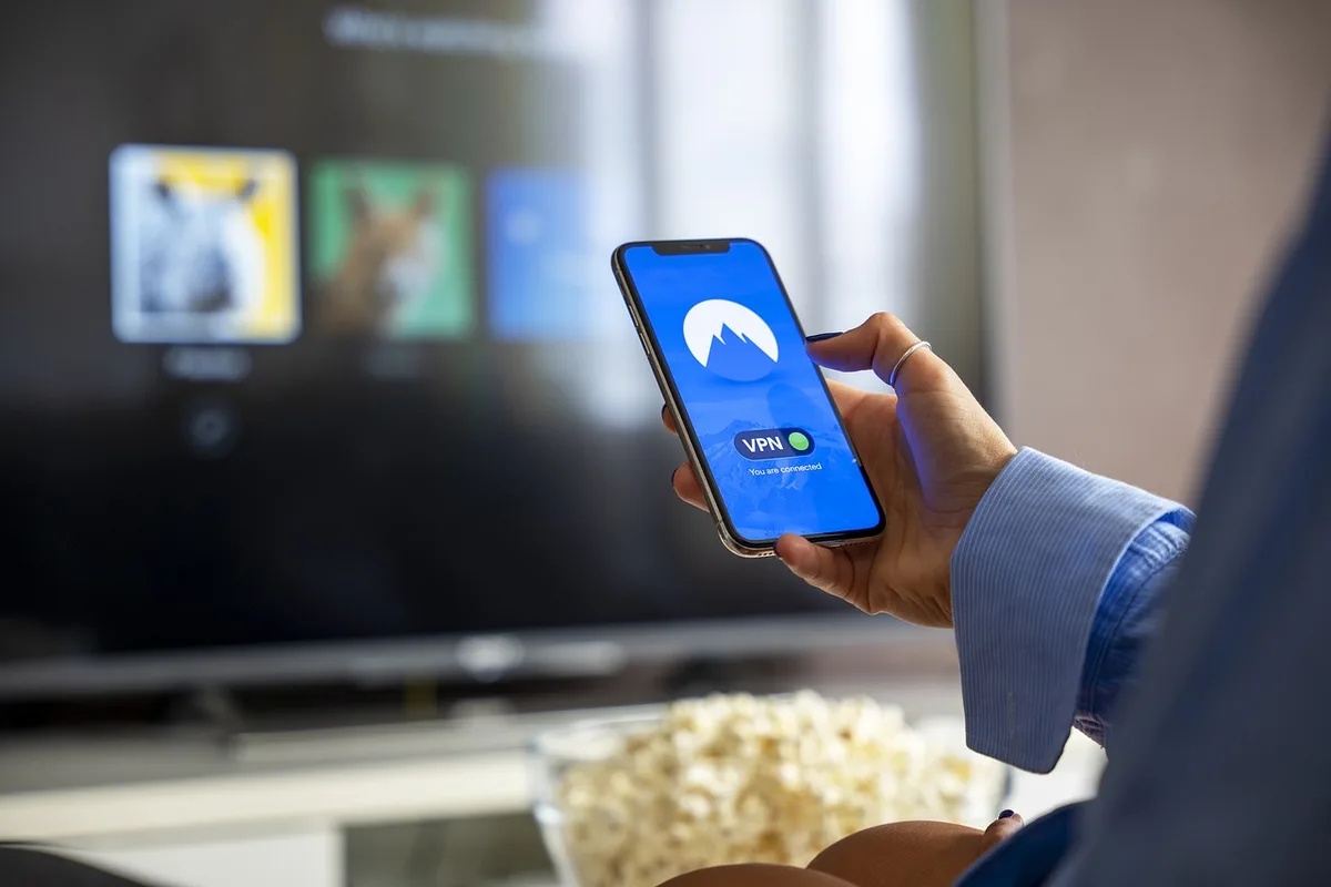 Google TV interface displayed on a 32-inch screen showing streaming apps and content library, warm ambient lighting reflecting off the metal frame, modern living room corner