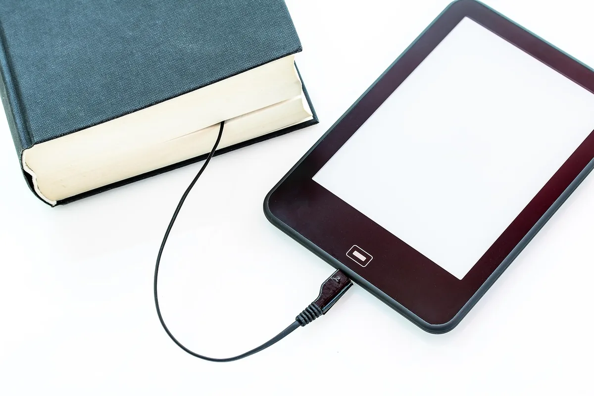 Foldable 3-in-1 wireless charger folded flat on a small table, no logos, compact gadget conveying portability