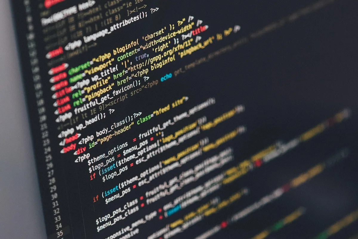 Wide empty developer workspace with an anonymous laptop showing an iPhone software update screen in blurred background