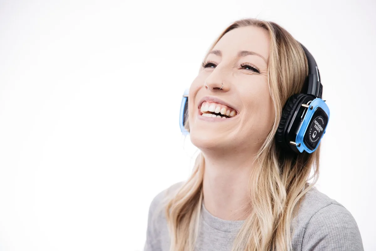 Wide editorial shot of an empty retail shelf with a single pair of generic over‑ear headphones boxed and a small price tag showing a discounted amount; quiet store interior in the background