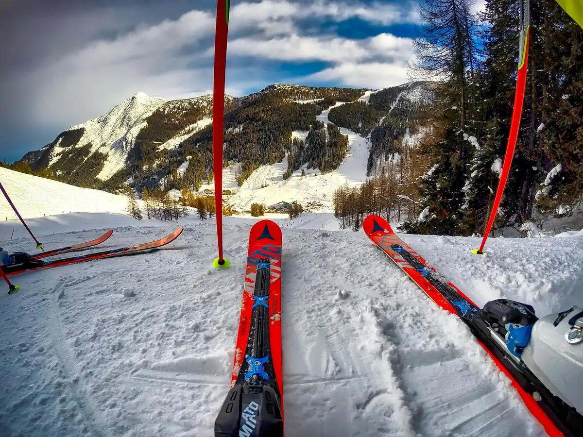 An anonymous pair of ski poles and goggles resting beside a generic smartwatch on a bench at a ski lodge interior; no brands or faces