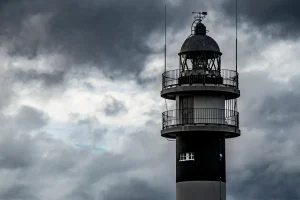 Paseo marítimo vacío con charcos tras lluvia y cielo nublado