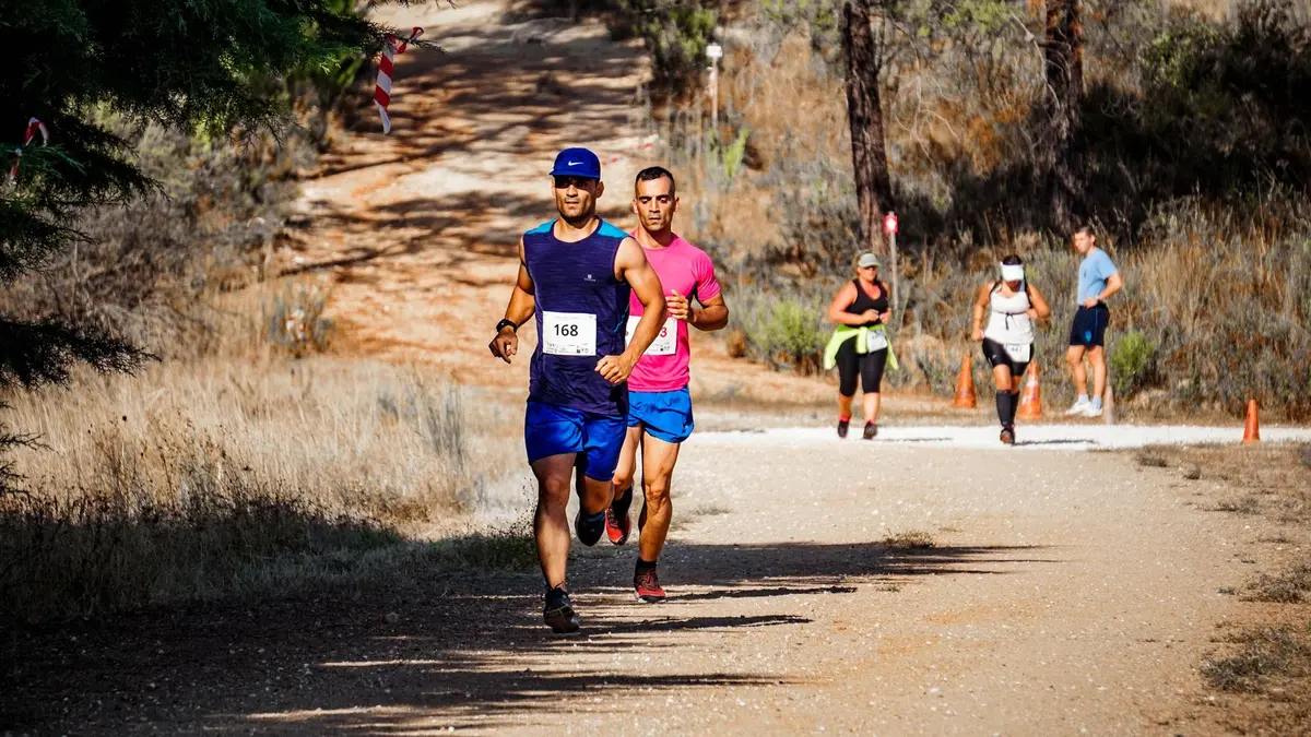 Corredores en una maratón y la señal de 42 km en la carretera