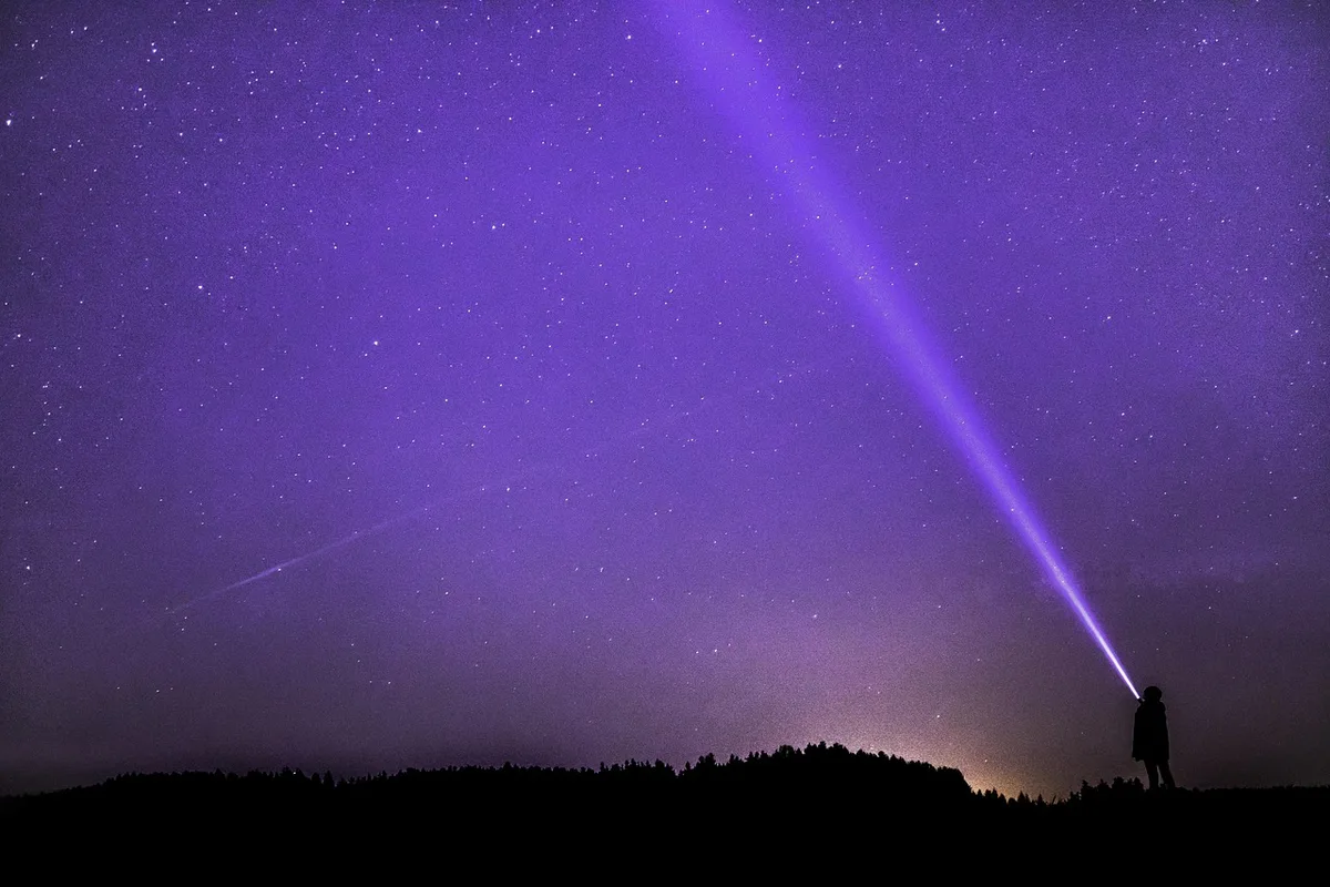 Observatorio nocturno con telescopio y pantalla que muestra curvas de luz de tránsitos planetarios