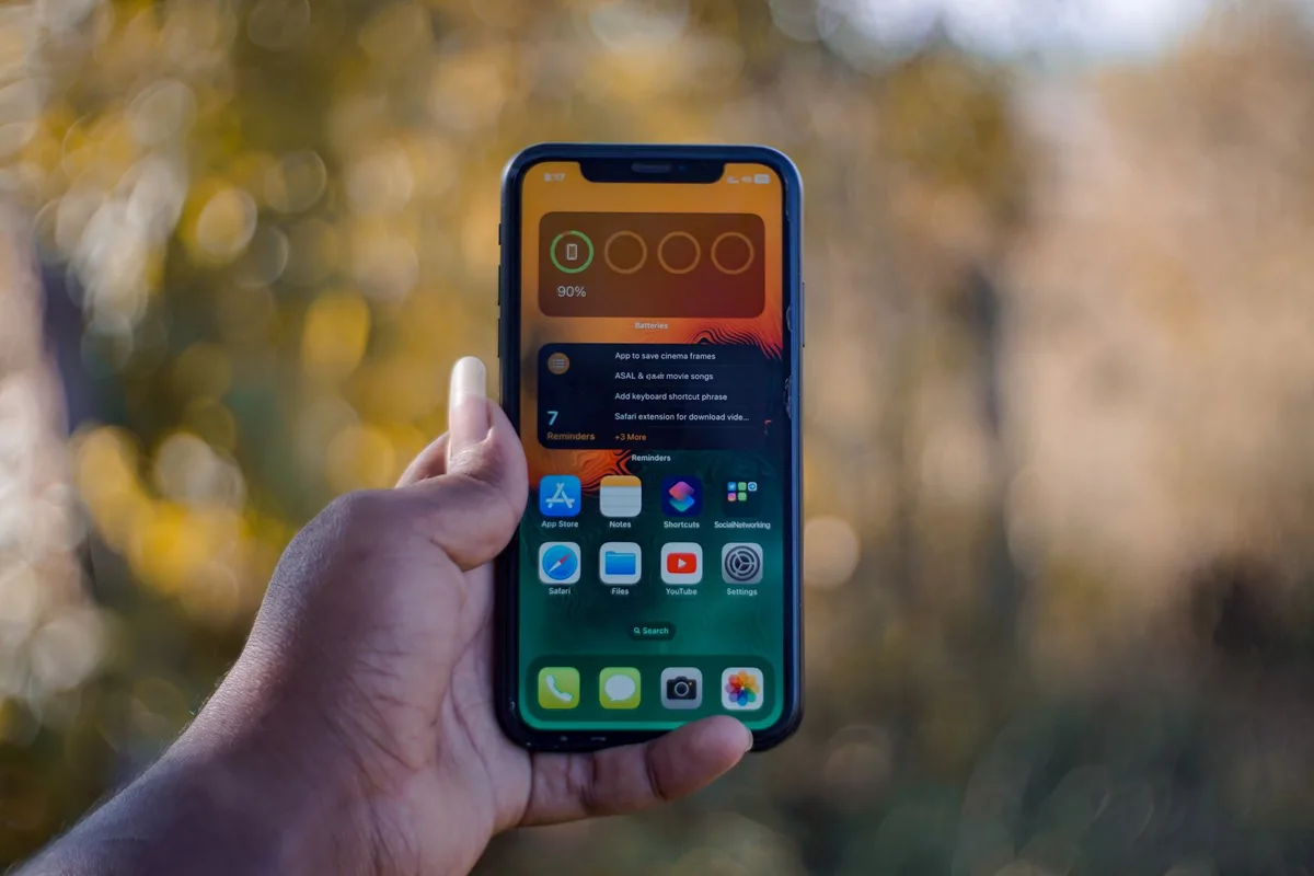 a person holding an anonymous mid-range phone showing update settings page, no brand visible